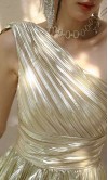 Front swirling view of a metallic champagne gold one-shoulder A-line prom gown with micro-pleated skirt detail